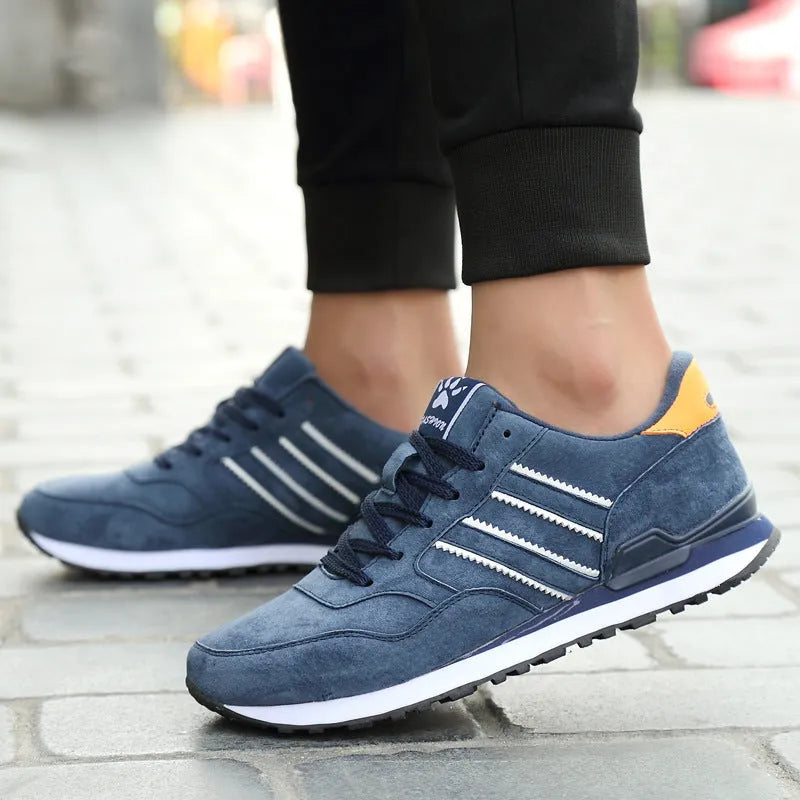 Men's blue pigskin leather sneakers with flat heel and rubber sole on grey background