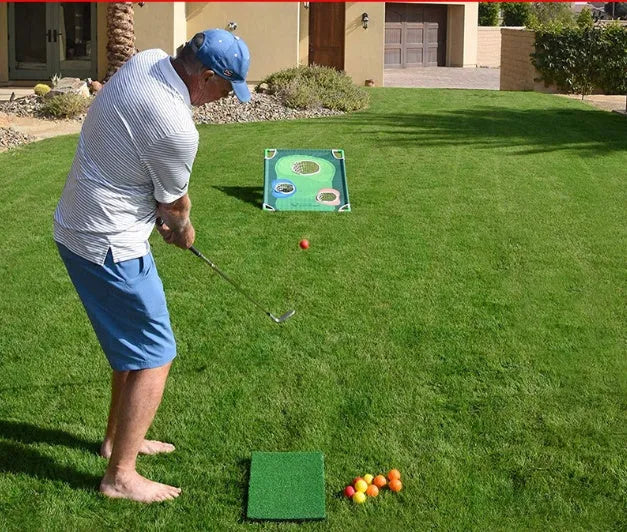 Green golf swing practice net with PVC frame and Oxford cloth target set up outdoors with balls and mat