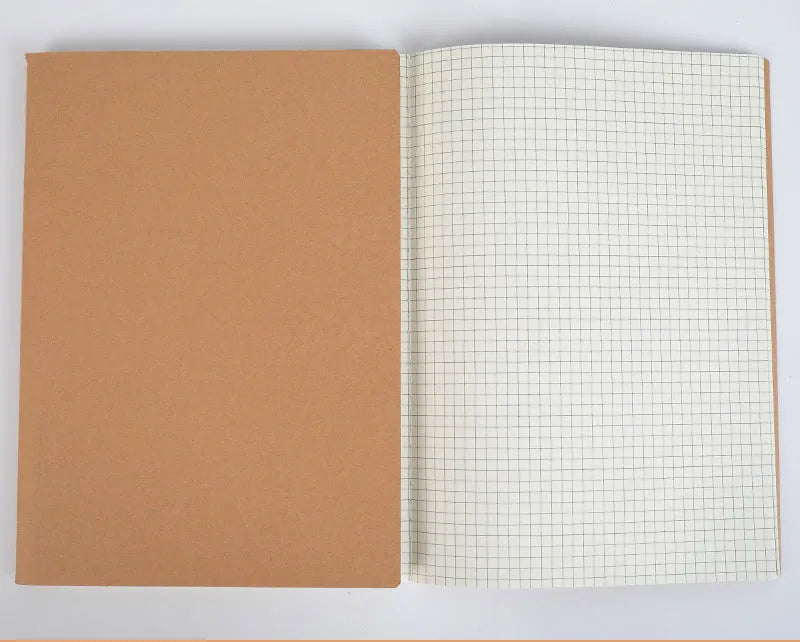 Beige leather thread bound notebook open on a table showing soft paper with ruled lines.