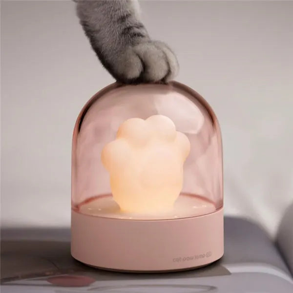 Grey cat paw shaped USB rechargeable night light with music box feature on wooden desk