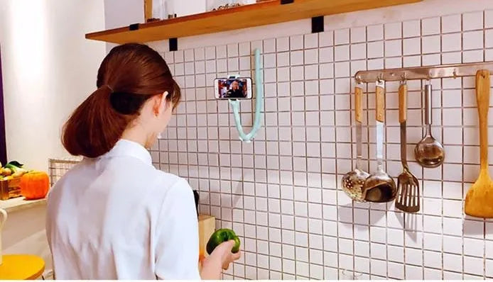 Black flexible arm phone holder with suction cup mounted on a desk, showing 360° rotation.