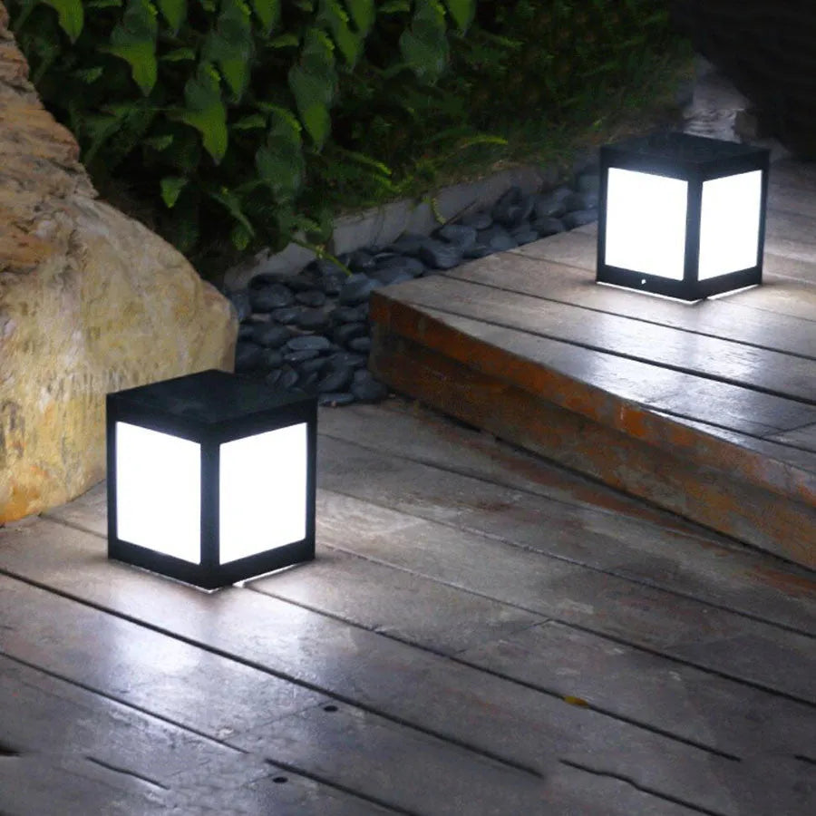 Solar-powered waterproof garden light installed on a lawn post providing white LED illumination.
