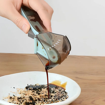 Blue adjustable measuring spoons with magnetic base showing measurement markings from 5ml to 130ml