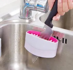 Blue kitchen cleaning brush with suction cup base for washing fruit, vegetables and cutlery.