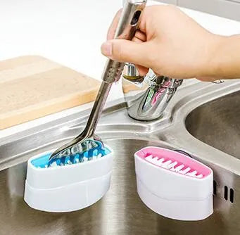 Blue kitchen cleaning brush with suction cup base for washing fruit, vegetables and cutlery.