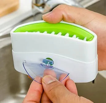 Blue kitchen cleaning brush with suction cup base for washing fruit, vegetables and cutlery.