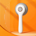 Blue and white self-cleaning pet grooming slicker brush for cats and dogs on a wooden surface.