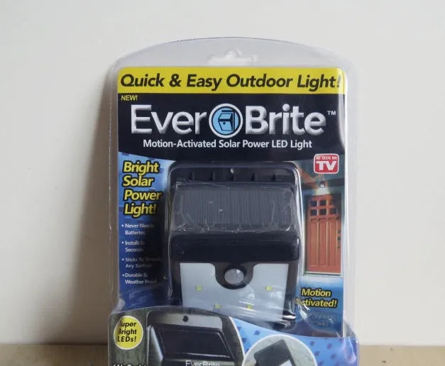 Set of four white rectangular solar-powered motion sensor lights for outdoor wall mounting.