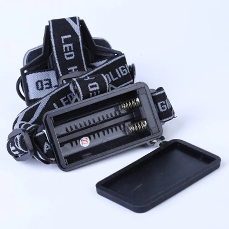 Fixed focus LED head torch with head strap, shown illuminating a long distance.