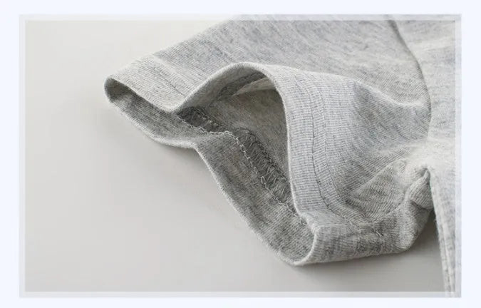 Grey cotton children's T-shirt laid flat, showing plain front and detailed size label.