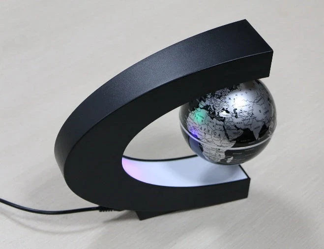 Magnetic levitation globe floating above base with LED light on