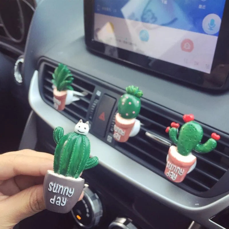 Car air freshener vent clip in plant ornament style, attached to car air conditioning vent