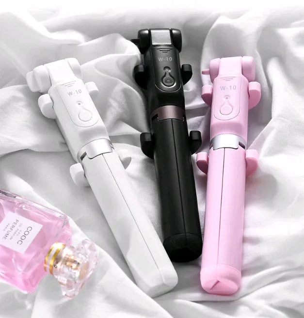 Aluminium telescopic Bluetooth selfie stick with tripod base and remote control next to a smartphone.