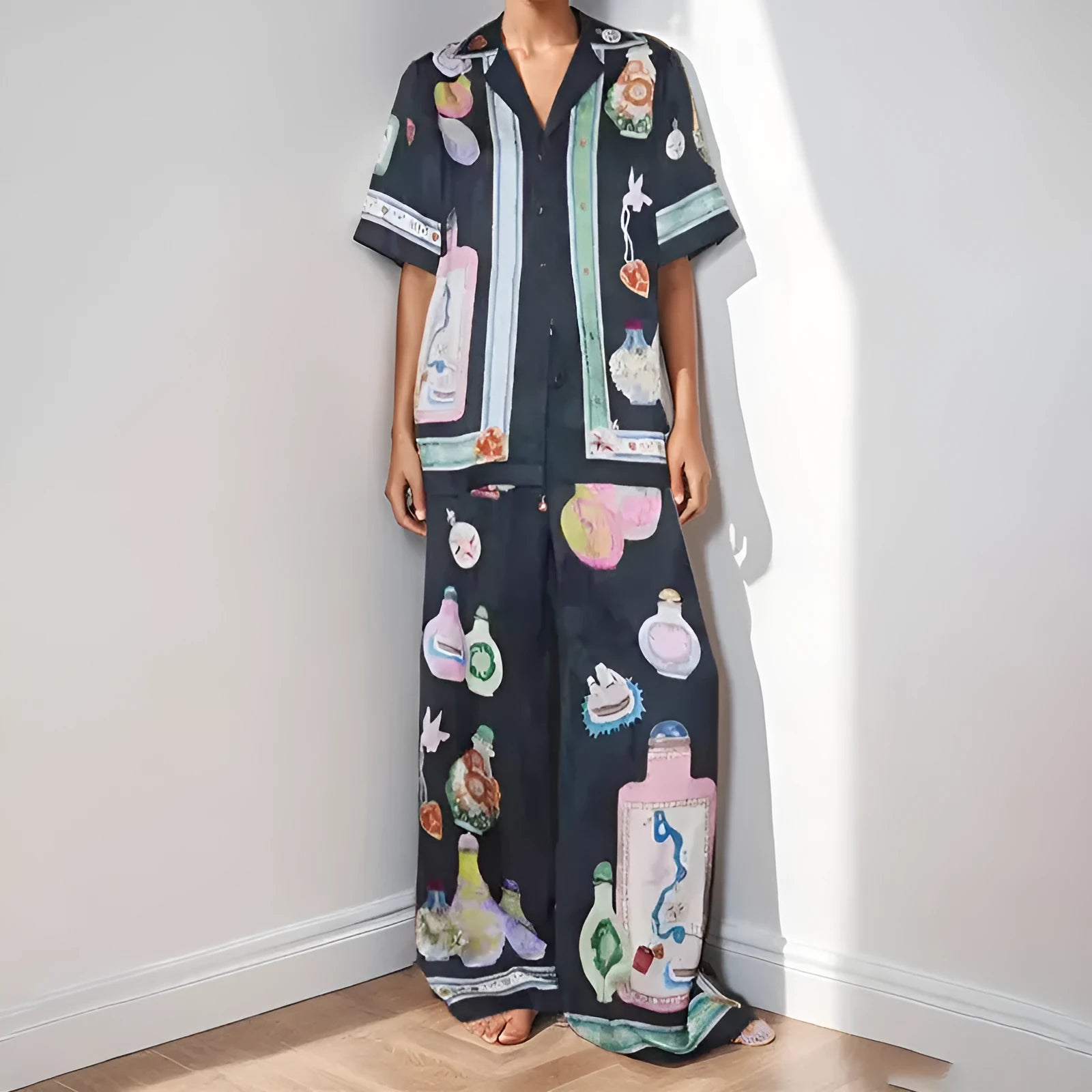 Black women's casual set with cartoon print, featuring a top with regular sleeves and matching trousers.