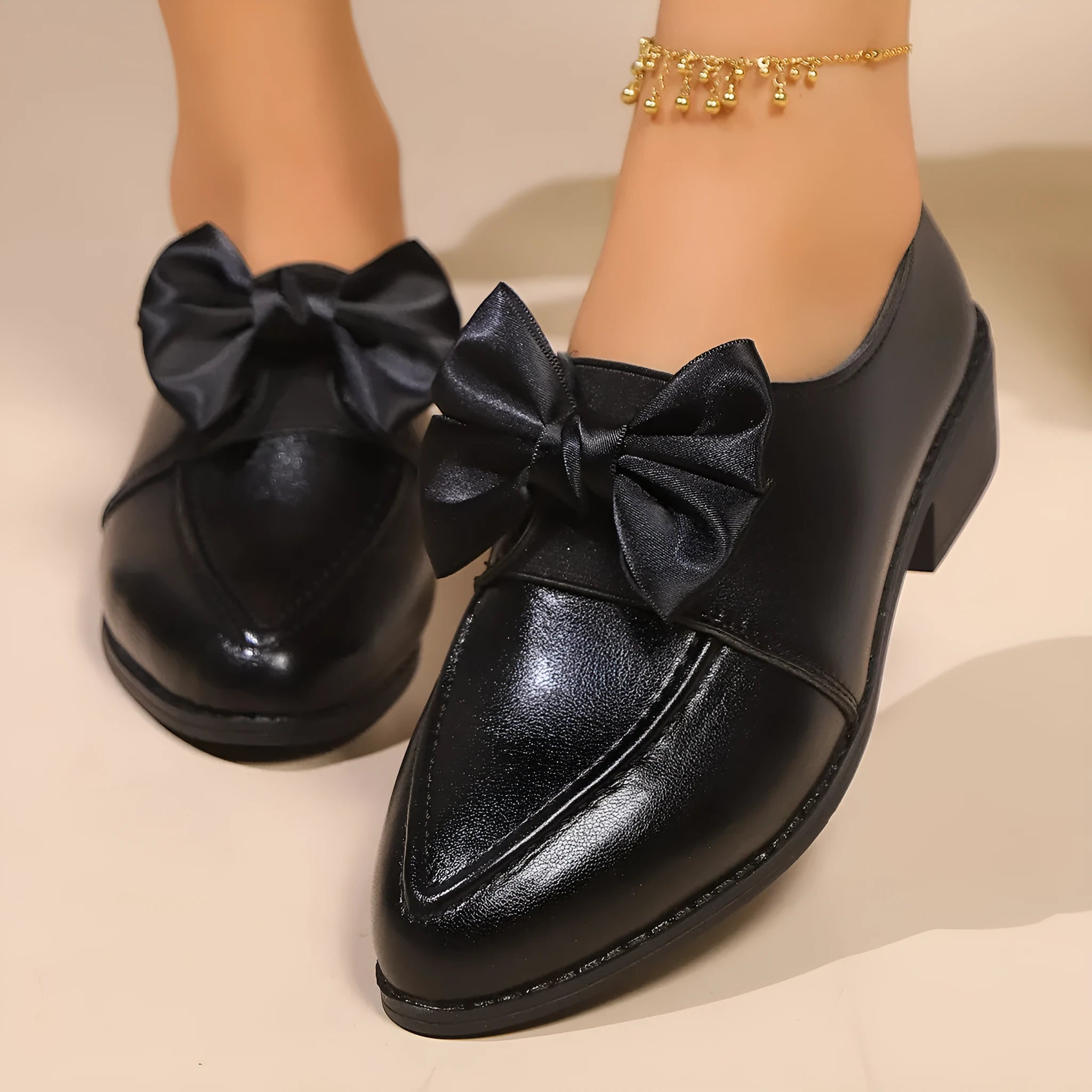 Women's pointed toe PU leather shoes with a bow detail on the upper.