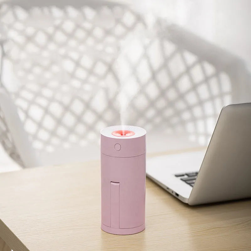 Blue folding bracket USB humidifier on a desk next to a laptop