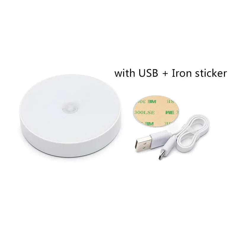 Small, round white LED night light with adhesive backing and a USB charging cable.