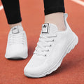 Women's white high-top casual shoes with cross-bind straps and a lace-up back closure on a flat sole.