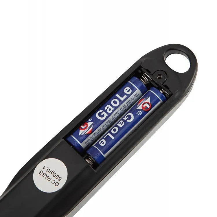 Smart digital kitchen measuring spoon with backlit LCD display showing weight and volume measurements.