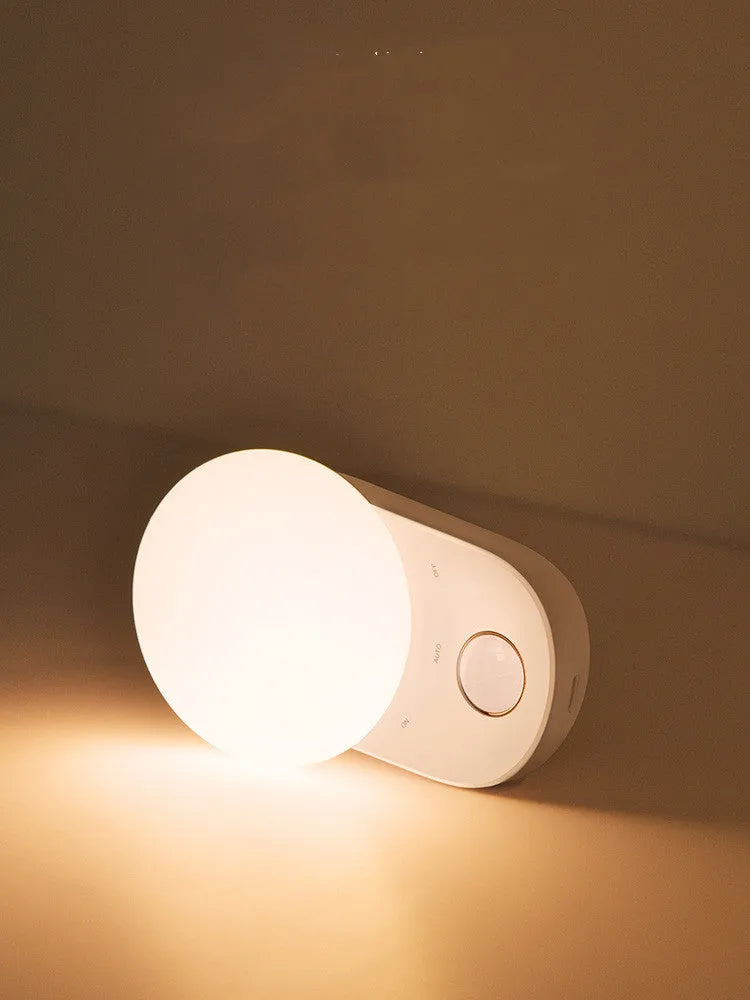 White Baseus Full Moon rechargeable LED sensor night light on a surface.