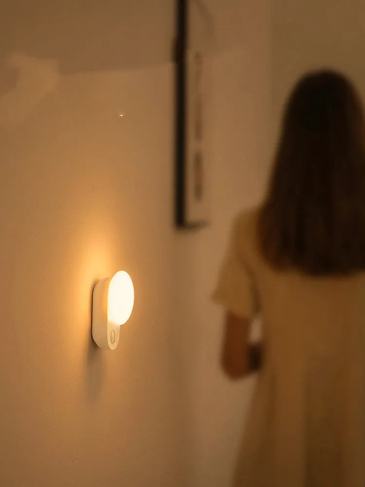 White Baseus Full Moon rechargeable LED sensor night light on a surface.