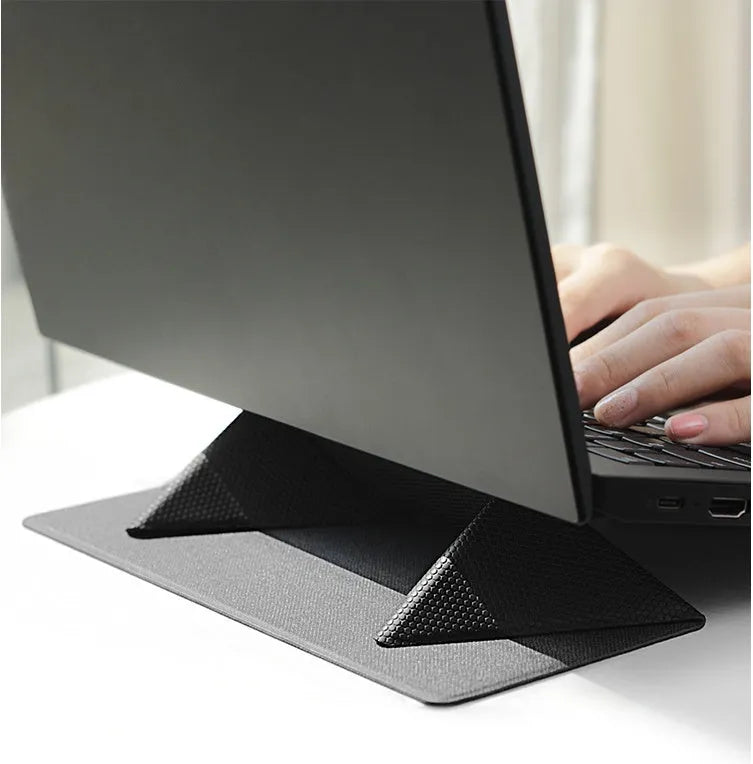 Blue foldable aluminium laptop cooling bracket open on a desk next to a laptop.