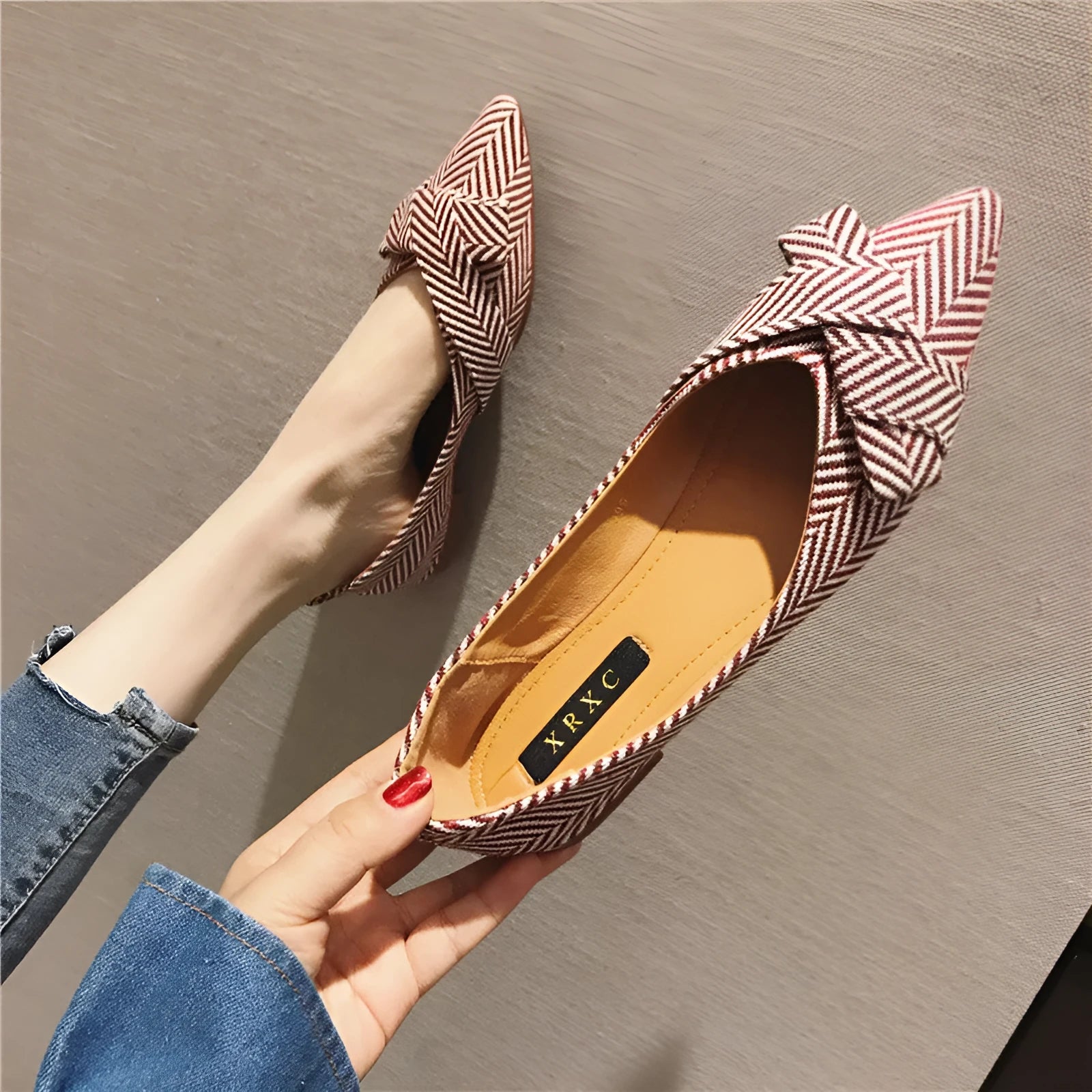 Women's red pointed-toe shallow-mouth flats with a low flat heel on a plain background.