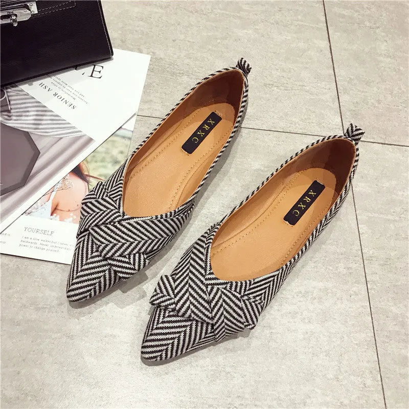 Women's red pointed-toe shallow-mouth flats with a low flat heel on a plain background.