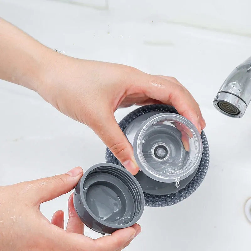 Kitchen cleaning brush with push-button soap dispenser and scrubber head.