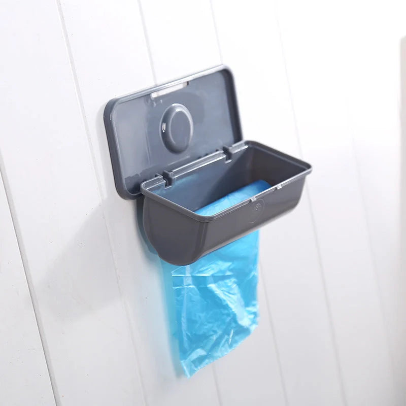 Wall-mounted plastic garbage bag holder in white, grey, and pink for kitchen organisation