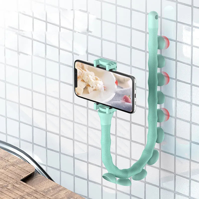 Black flexible arm phone holder with suction cup mounted on a desk, showing 360° rotation.