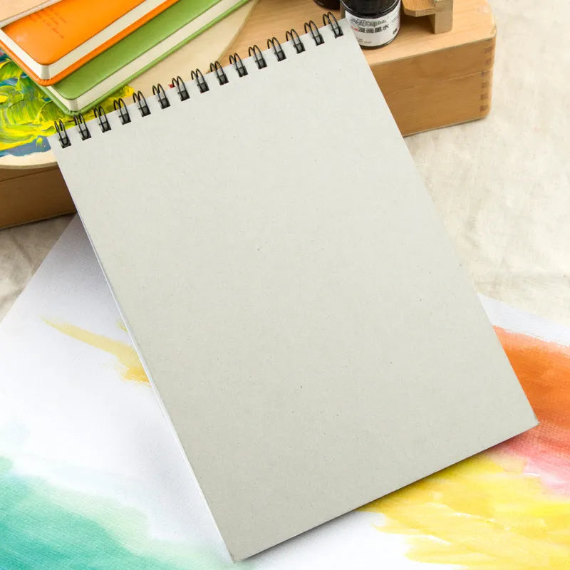 Green paper water-soluble lead sketchbook open flat showing spiral binding and 8K or 16K size