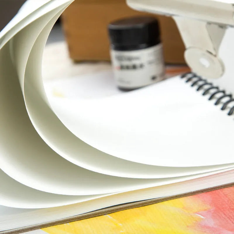 Green paper water-soluble lead sketchbook open flat showing spiral binding and 8K or 16K size