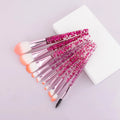 10 makeup brushes with pink powder-filled handles and nylon bristles arranged in a fan shape