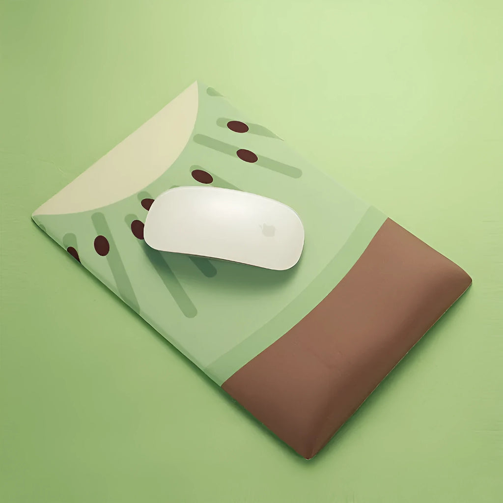 Green kiwi fruit shaped mouse pad with integrated soft wrist support cushion on a desk.