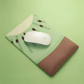 Green kiwi fruit shaped mouse pad with integrated soft wrist support cushion on a desk.