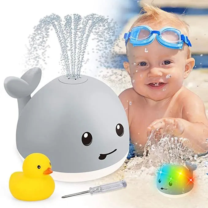 Grey and white cartoon whale bath toy spraying water with LED lights glowing