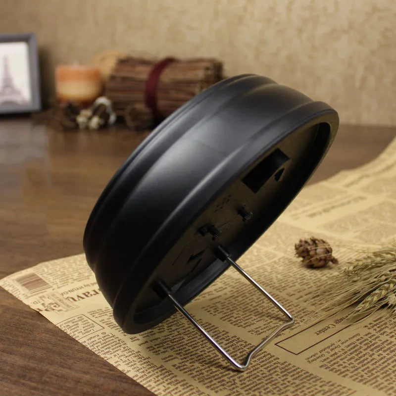 Round retro-style 6-inch desk alarm clock with a plastic case on a wooden surface.