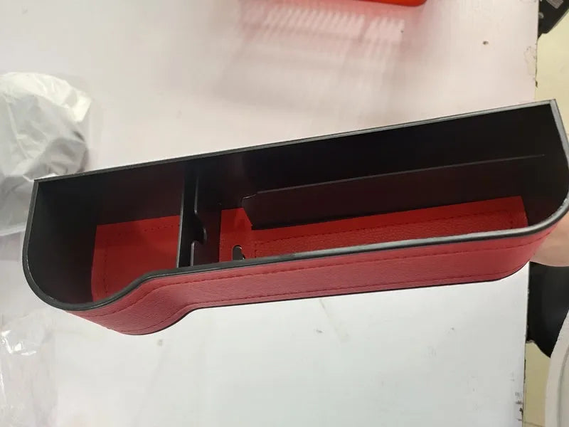 PU leather car seat gap storage box in black, showing phone and cup storage between seat and console