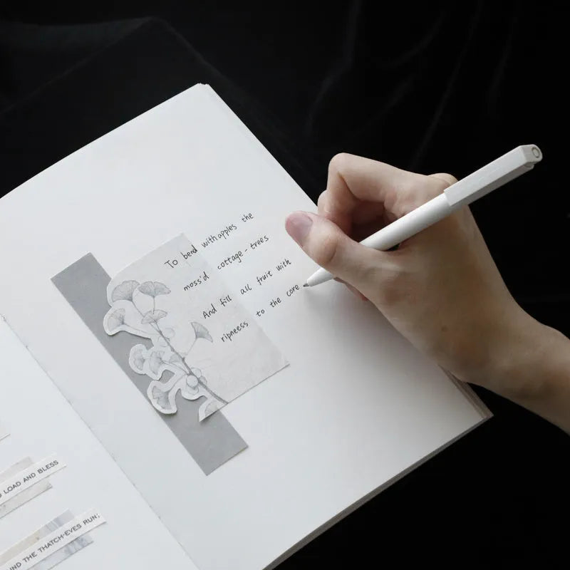 Soft red imitation leather notebook with bronzing detail, open to show dot grid inner pages.