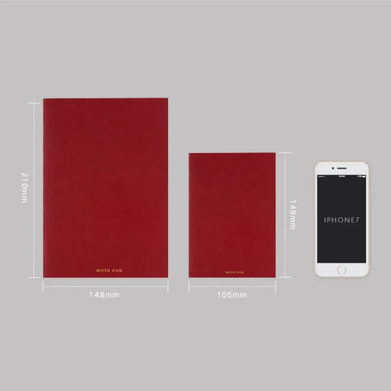 Soft red imitation leather notebook with bronzing detail, open to show dot grid inner pages.