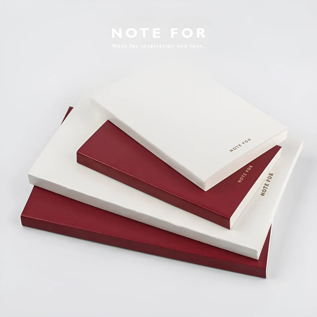 Soft red imitation leather notebook with bronzing detail, open to show dot grid inner pages.