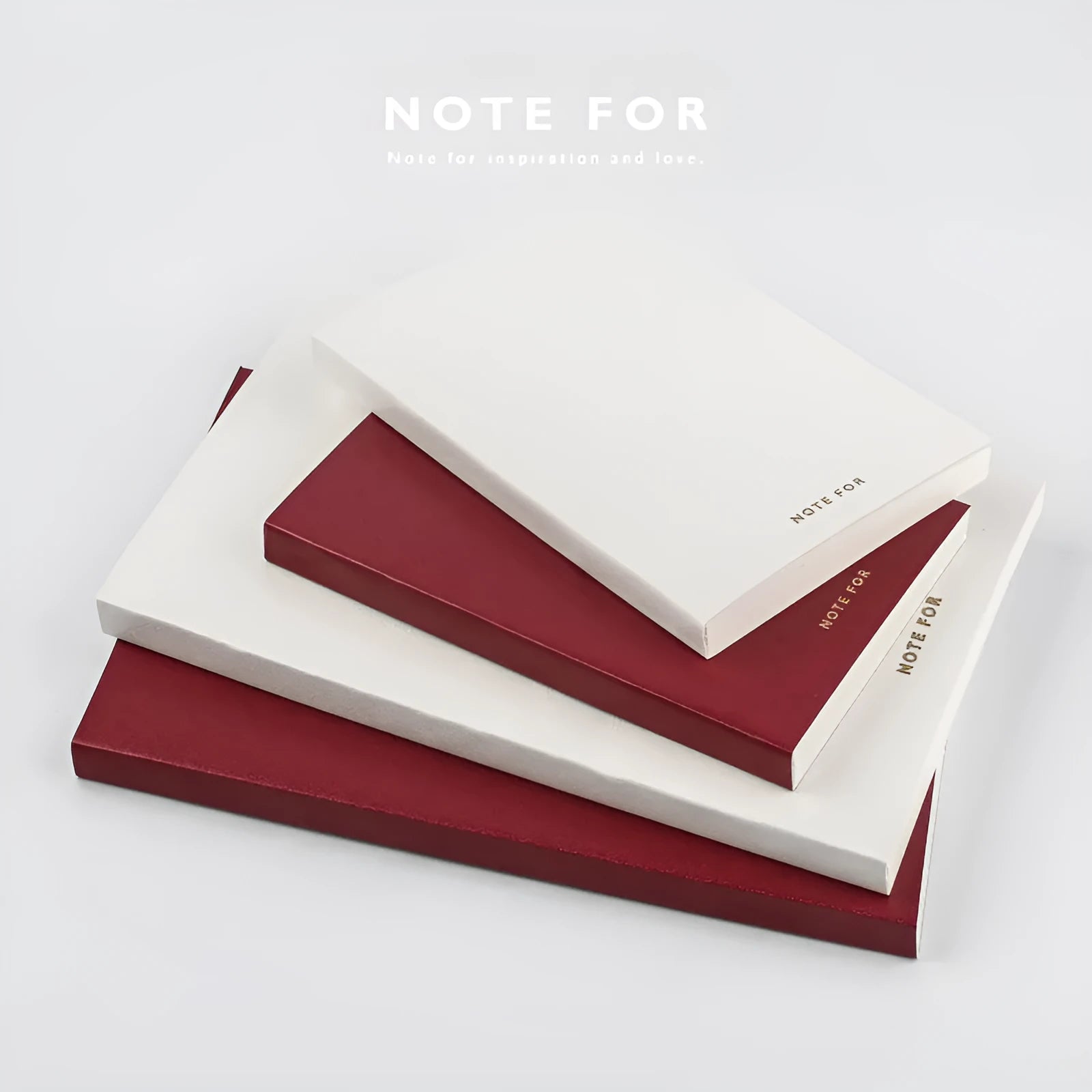 Soft red imitation leather notebook with bronzing detail, open to show dot grid inner pages.