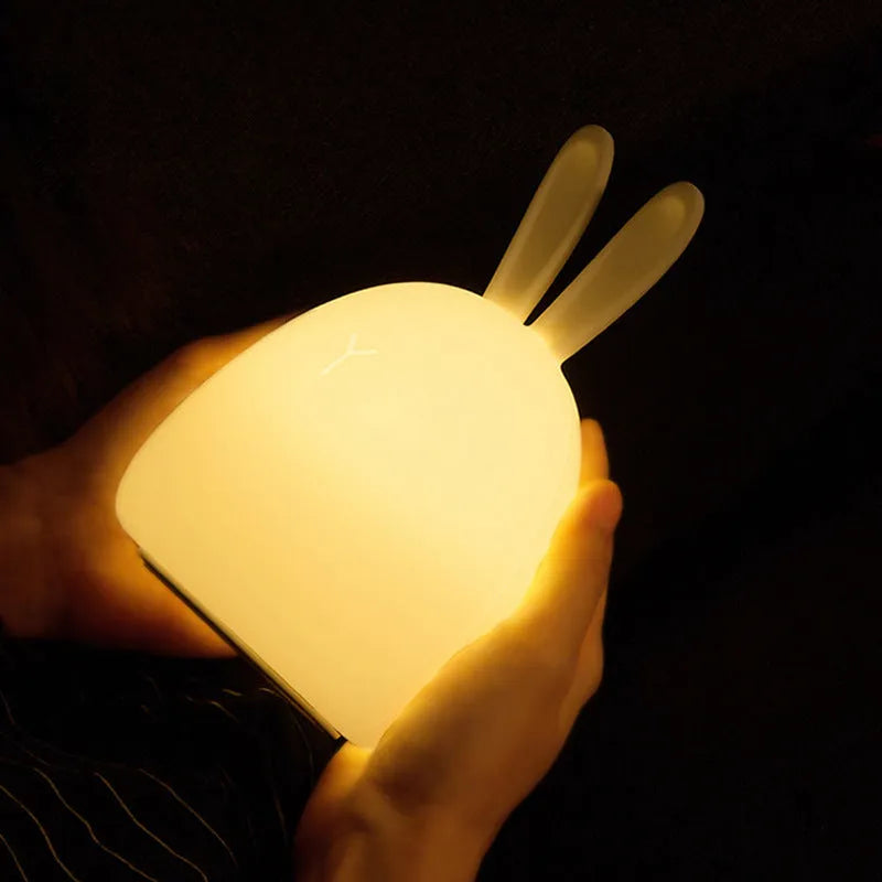 White fat rabbit silicone lamp with touch switch and charging base on a plain background
