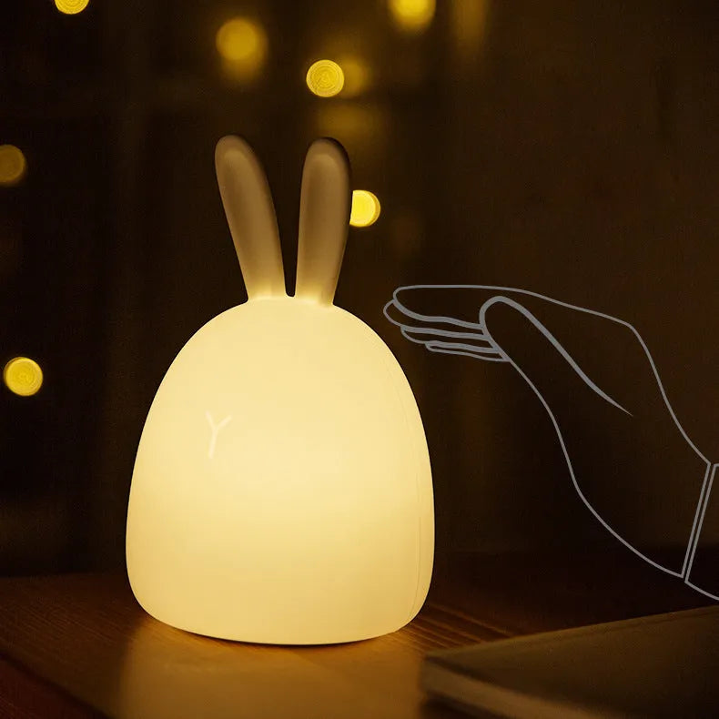 White fat rabbit silicone lamp with touch switch and charging base on a plain background