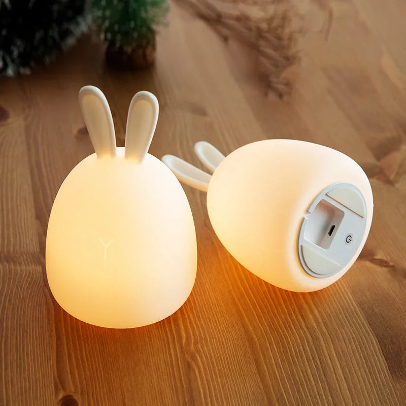 White fat rabbit silicone lamp with touch switch and charging base on a plain background