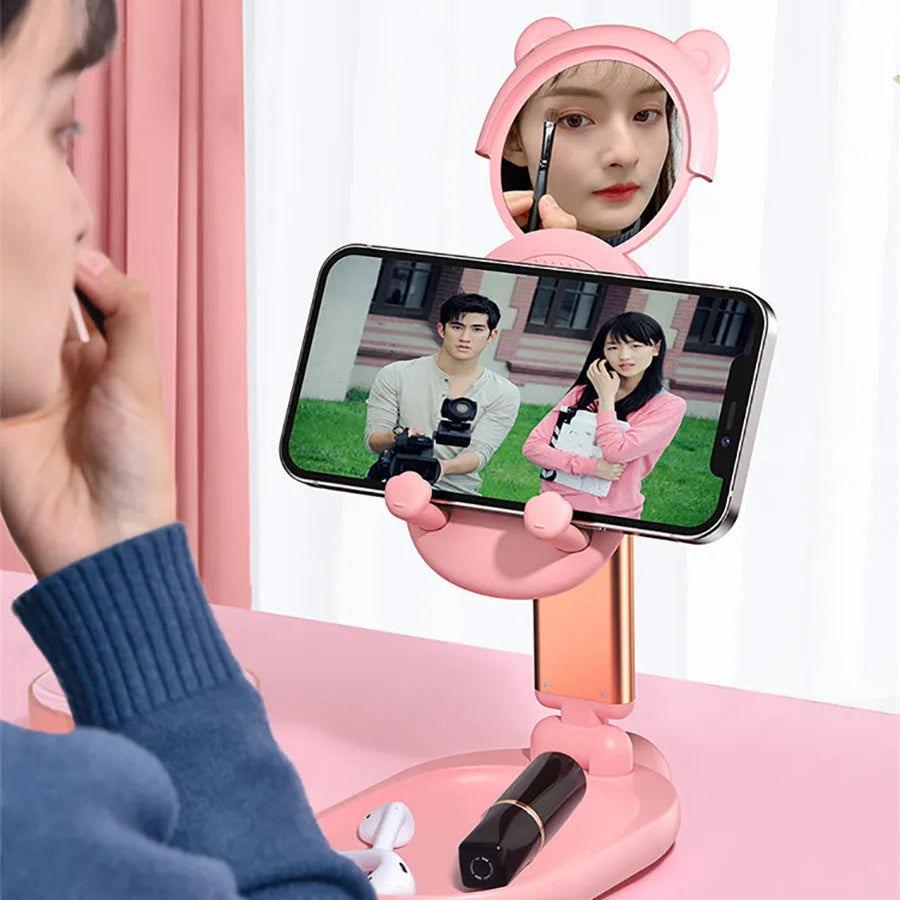 Adjustable blue desk stand holding an iPhone, showing its built-in mirror and foldable design.