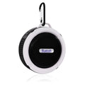 White waterproof Bluetooth speaker with suction cup attached to bathroom tile