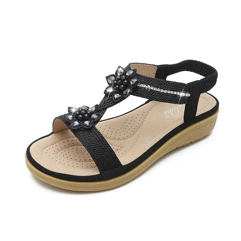 Boho flat flower rhinestone sandals in apricot with round toe and back strap on a plain background
