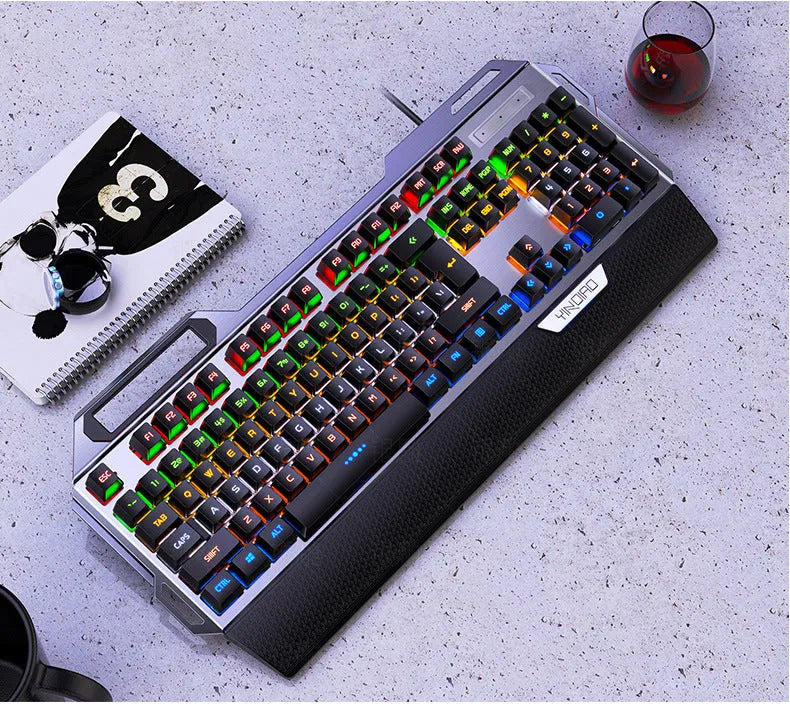 Silver Carving K100 metal mechanical keyboard with black axis keys, seven-color backlight, large hand rest, and phone holder on a desk